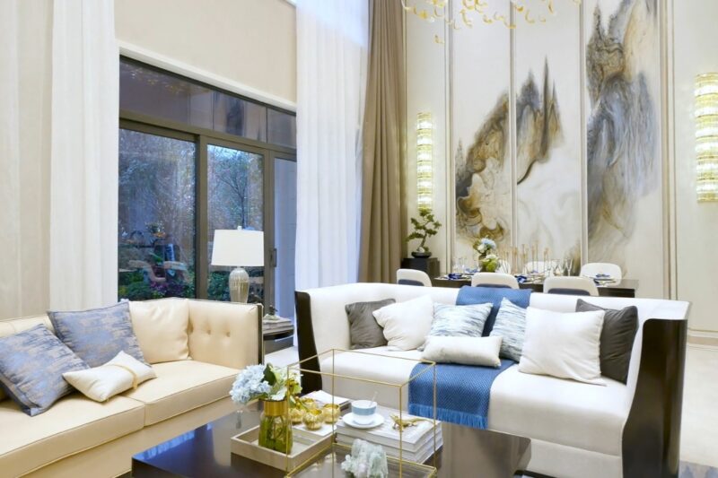 prikaz neutralno sređene dnevne sobe sa ugaonom, dvosedom, pločicama na zidu i stolčićem