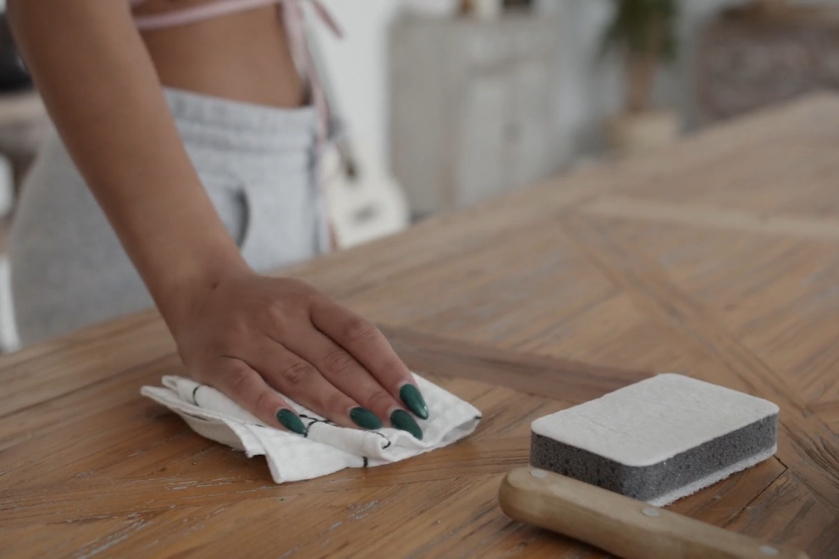 devojka briše drveni sto