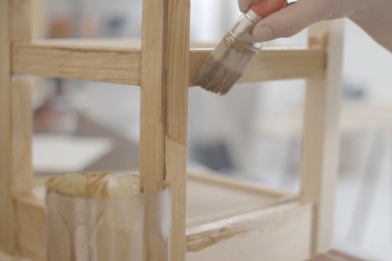 osoba farba drvenu stolicu